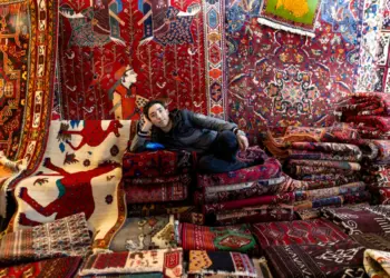 Un vendedor de alfombras posa para un retrato en un mercado semanal de los viernes en Teherán, Irán, el 16 de enero de 2026. (Stringer/Getty Images)