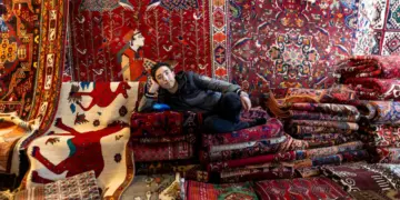 Un vendedor de alfombras posa para un retrato en un mercado semanal de los viernes en Teherán, Irán, el 16 de enero de 2026. (Stringer/Getty Images)