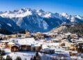 El pueblo de Aussois, Francia, cubierto de nieve con montañas al fondo.