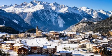 El pueblo de Aussois, Francia, cubierto de nieve con montañas al fondo.