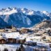 El pueblo de Aussois, Francia, cubierto de nieve con montañas al fondo.