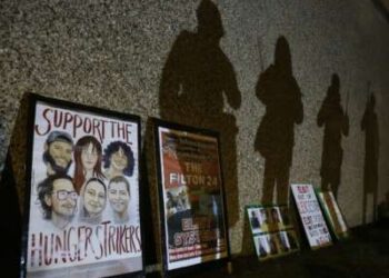 Las sombras de los manifestantes se proyectan en los muros de la prisión encima de carteles en apoyo a los huelguistas de hambre. Los partidarios de Filton 24, un grupo de activistas pro palestinos, se manifestaron frente al HMP Peterborough en solidaridad con los 24 prisioneros en prisión preventiva y los seis que se encuentran actualmente en huelga de hambre en prisiones de todo el Reino Unido.