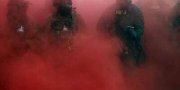 Agentes federales, incluidos miembros del Departamento de Seguridad Nacional y la Patrulla Fronteriza, despliegan una granada de humo afuera de una instalación del Servicio de Inmigración y Control de Aduanas en el centro de Portland, Oregon, el 4 de octubre de 2025.