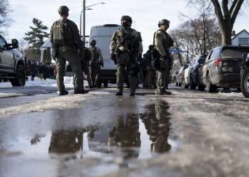 Los agentes del sheriff del condado de Hennepin observan mientras los miembros de las fuerzas del orden mantienen un perímetro alrededor de la escena de un tiroteo por parte de un agente de ICE durante las operaciones federales de aplicación de la ley el 7 de enero de 2026 en Minneapolis, Minnesota.