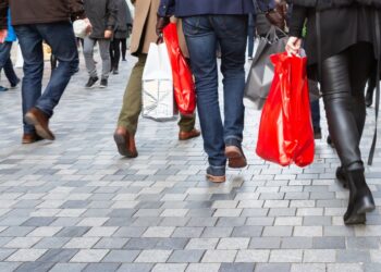 Personas con bolsas de compras caminan por la zona peatonal.