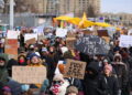 People holding up signs protest on the streets