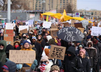 People holding up signs protest on the streets