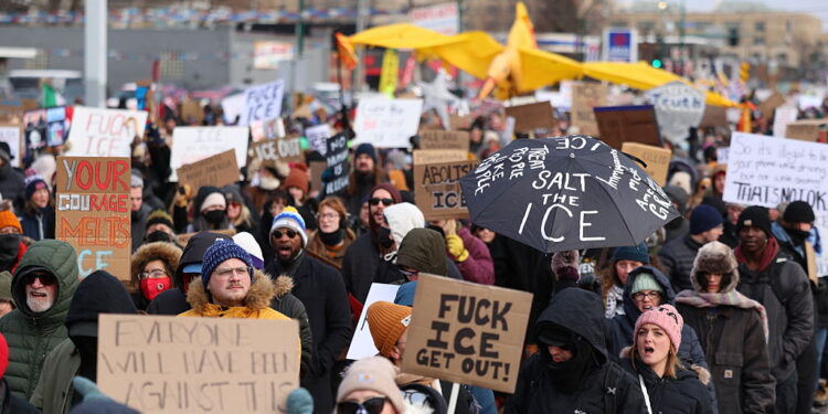 People holding up signs protest on the streets