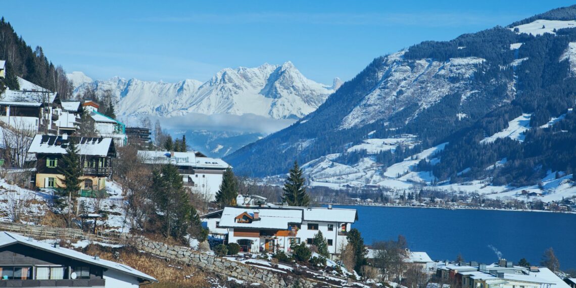 Un collage de imágenes que contiene 1 imágenes. La imagen 1 muestra una vista panorámica de Zell am See, Austria, con montañas cubiertas de nieve, un lago y edificios en primer plano.