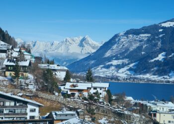 Un collage de imágenes que contiene 1 imágenes. La imagen 1 muestra una vista panorámica de Zell am See, Austria, con montañas cubiertas de nieve, un lago y edificios en primer plano.
