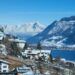 Un collage de imágenes que contiene 1 imágenes. La imagen 1 muestra una vista panorámica de Zell am See, Austria, con montañas cubiertas de nieve, un lago y edificios en primer plano.