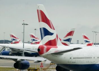 Un collage de imágenes que contiene 1 imagen. La imagen 1 muestra varios aviones de British Airways estacionados en un día nublado.