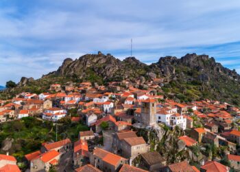 Un collage de imágenes que contiene 1 imágenes. La imagen 1 muestra una vista aérea del histórico pueblo de Monsanto en Portugal, con casas tradicionales ubicadas entre grandes rocas de granito.