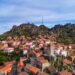 Un collage de imágenes que contiene 1 imágenes. La imagen 1 muestra una vista aérea del histórico pueblo de Monsanto en Portugal, con casas tradicionales ubicadas entre grandes rocas de granito.