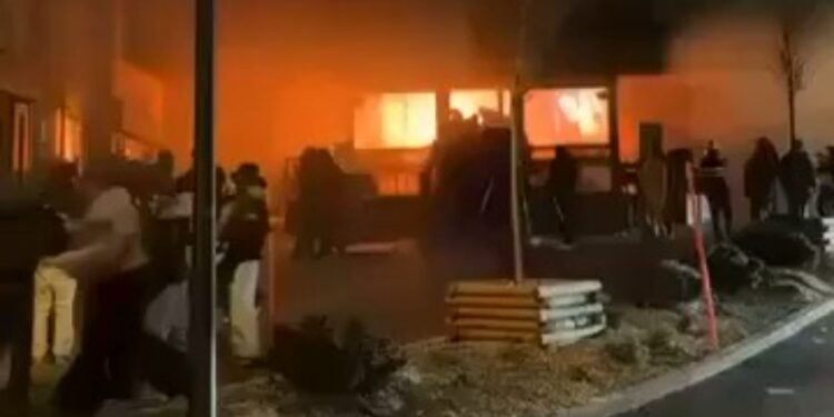 Edificio envuelto en llamas, del que sale humo.