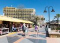 Un collage de imágenes que contiene 1 imágenes. La imagen 1 muestra hoteles y una playa en Torremolinos, con gente caminando por un paseo marítimo.