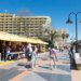 Un collage de imágenes que contiene 1 imágenes. La imagen 1 muestra hoteles y una playa en Torremolinos, con gente caminando por un paseo marítimo.