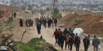 Palestinos desplazados cruzan el corredor Netzarim mientras se dirigen al norte de la Franja de Gaza el 9 de febrero de 2025.