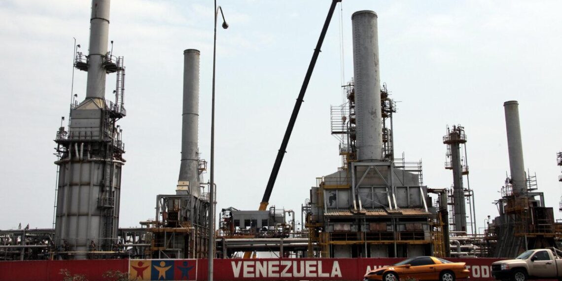Los automóviles pasan por la refinería de petróleo en la ciudad venezolana de Morón el 30 de abril de 2009. El sector petrolero domina la economía mixta de Venezuela y representa alrededor del 80 por ciento de las exportaciones. (Thomas Coex/AFP vía Getty Images)
