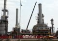 Los automóviles pasan por la refinería de petróleo en la ciudad venezolana de Morón el 30 de abril de 2009. El sector petrolero domina la economía mixta de Venezuela y representa alrededor del 80 por ciento de las exportaciones. (Thomas Coex/AFP vía Getty Images)