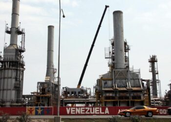 Los automóviles pasan por la refinería de petróleo en la ciudad venezolana de Morón el 30 de abril de 2009. El sector petrolero domina la economía mixta de Venezuela y representa alrededor del 80 por ciento de las exportaciones. (Thomas Coex/AFP vía Getty Images)