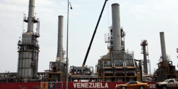 Los automóviles pasan por la refinería de petróleo en la ciudad venezolana de Morón el 30 de abril de 2009. El sector petrolero domina la economía mixta de Venezuela y representa alrededor del 80 por ciento de las exportaciones. (Thomas Coex/AFP vía Getty Images)