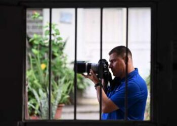 El periodista salvadoreño Mario Guevara, de 48 años, deportado de Estados Unidos, es fotografiado sosteniendo su cámara en la casa de un familiar en Apopa, El Salvador, el 6 de octubre de 2025.