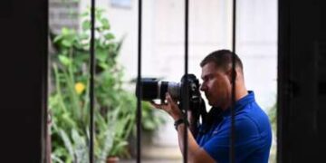 El periodista salvadoreño Mario Guevara, de 48 años, deportado de Estados Unidos, es fotografiado sosteniendo su cámara en la casa de un familiar en Apopa, El Salvador, el 6 de octubre de 2025.