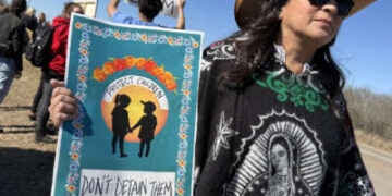 Un manifestante sostiene un cartel que dice "Proteja a los niños/No los detenga" mientras la gente se reúne durante una manifestación y vigilia frente al Centro Residencial Familiar del Sur de Texas en Dilley, Texas, el 28 de enero de 2026.