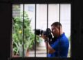 El periodista salvadoreño Mario Guevara, de 48 años, deportado de Estados Unidos, es fotografiado sosteniendo su cámara en la casa de un familiar en Apopa, El Salvador, el 6 de octubre de 2025.