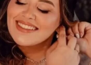 Un collage de imágenes que contiene 1 imagen. La imagen 1 muestra un collage de un edificio negro con marcos de ventanas naranjas y un coche de policía estacionado enfrente, y una mujer sonriente poniéndose un arete.