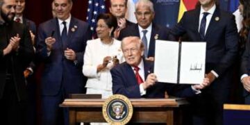 Donald Trump sostiene un documento que indica un EE.UU. "Compromiso para contrarrestar la actividad criminal de los cárteles" que firmó rodeado de jefes de estado y funcionarios de gobierno de 12 países de las Américas mientras organiza la “Cumbre El Escudo de las Américas” en el Trump National Doral Golf Club el 7 de marzo de 2026, en Doral, Florida. La Casa Blanca describe la reunión como una cumbre histórica destinada a remodelar las alianzas regionales y reforzar la influencia de Estados Unidos en el hemisferio occidental.