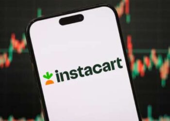 El logotipo de Maplebear Inc., que opera como Instacart, se muestra en la pantalla de un teléfono inteligente, con el último gráfico del mercado de valores de la compañía visible en el fondo.