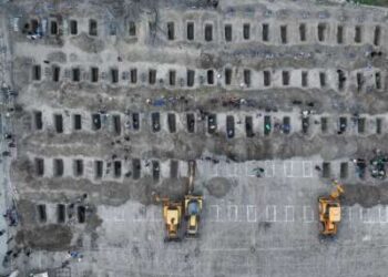 En esta imagen aérea publicada por el Centro de Prensa Iraní, los dolientes cavan tumbas durante el funeral de los niños muertos en un ataque a una escuela primaria en la provincia iraní de Hormozgan, en Minab, el 3 de marzo de 2026.
