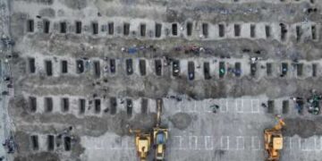 En esta imagen aérea publicada por el Centro de Prensa Iraní, los dolientes cavan tumbas durante el funeral de los niños muertos en un ataque a una escuela primaria en la provincia iraní de Hormozgan, en Minab, el 3 de marzo de 2026.