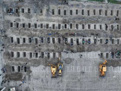 En esta imagen aérea publicada por el Centro de Prensa Iraní, los dolientes cavan tumbas durante el funeral de los niños muertos en un ataque a una escuela primaria en la provincia iraní de Hormozgan, en Minab, el 3 de marzo de 2026.