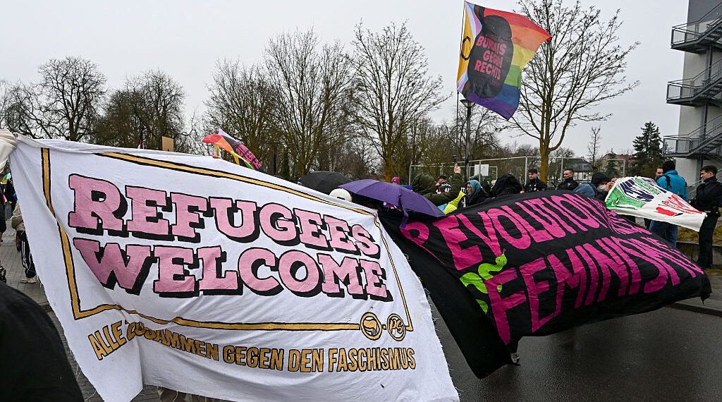 Counter demonstrators hold up a “refugees welcome” banner