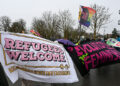 Counter demonstrators hold up a “refugees welcome” banner