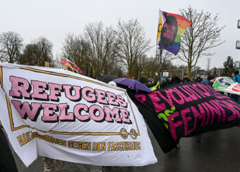 Counter demonstrators hold up a “refugees welcome” banner