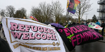 Counter demonstrators hold up a “refugees welcome” banner