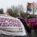 Counter demonstrators hold up a “refugees welcome” banner