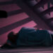 Una ilustración muestra a una persona durmiendo debajo de una escalera.