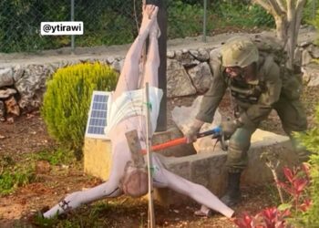 An Israeli soldier smashes the face of a Jesus Christ statue with a sledgehammer in southern Lebanon.