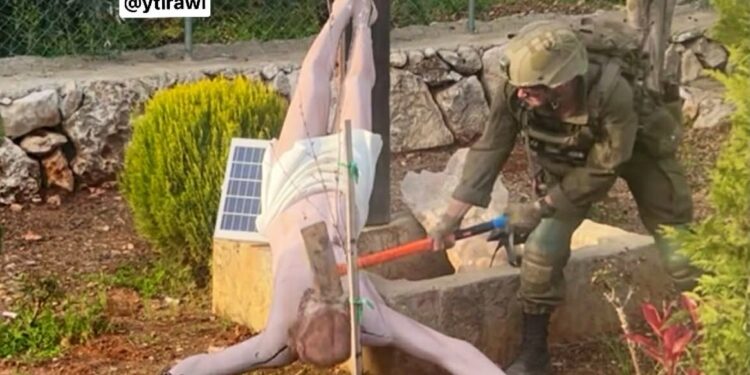 An Israeli soldier smashes the face of a Jesus Christ statue with a sledgehammer in southern Lebanon.