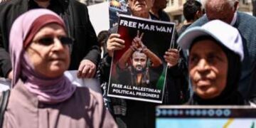 Manifestantes palestinos sostienen fotografías de prisioneros retenidos en cárceles israelíes, incluido el líder palestino encarcelado Marwan Barghouti, durante una manifestación en Ramallah, en la Cisjordania ocupada, el 16 de abril de 2026, para conmemorar el Día de los Prisioneros y protestar contra la aprobación por parte del parlamento israelí de un nuevo proyecto de ley de pena de muerte para los palestinos.