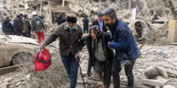 Una anciana recibe ayuda desde el lugar de un ataque a un edificio residencial el 16 de marzo de 2026 en Teherán, Irán.