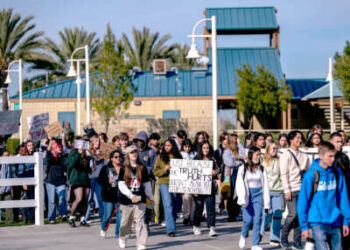 Los estudiantes realizan una huelga de la escuela mientras marchan detrás de una pancarta que dice "SÓLO PORQUE LA VERDAD DUELE NO SIGNIFICA DEJAR DE ENSEÑARLA"