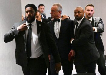 El Secretario de Salud y Servicios Humanos de Estados Unidos, Robert F. Kennedy Jr., es sacado rápidamente por agentes del Servicio Secreto después de que se escucharon fuertes golpes durante la cena de corresponsales de la Casa Blanca en el Washington Hilton en Washington el 25 de abril de 2026. (Mandel Ngan/AFP vía Getty Images)