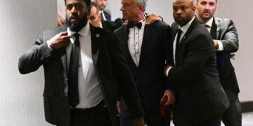 El Secretario de Salud y Servicios Humanos de Estados Unidos, Robert F. Kennedy Jr., es sacado rápidamente por agentes del Servicio Secreto después de que se escucharon fuertes golpes durante la cena de corresponsales de la Casa Blanca en el Washington Hilton en Washington el 25 de abril de 2026. (Mandel Ngan/AFP vía Getty Images)