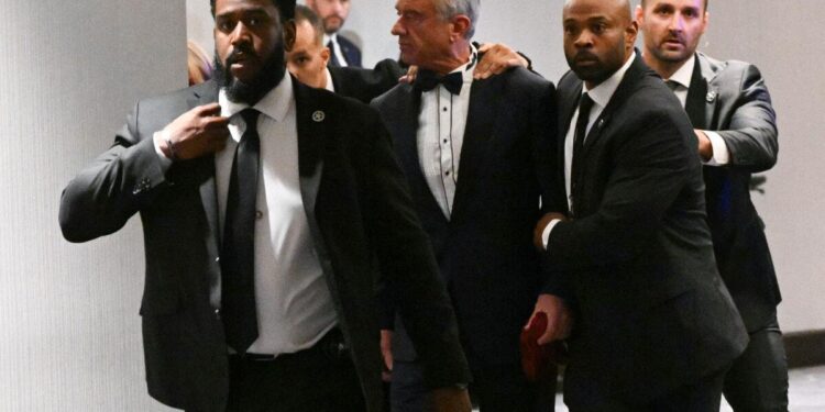 El Secretario de Salud y Servicios Humanos de Estados Unidos, Robert F. Kennedy Jr., es sacado rápidamente por agentes del Servicio Secreto después de que se escucharon fuertes golpes durante la cena de corresponsales de la Casa Blanca en el Washington Hilton en Washington el 25 de abril de 2026. (Mandel Ngan/AFP vía Getty Images)